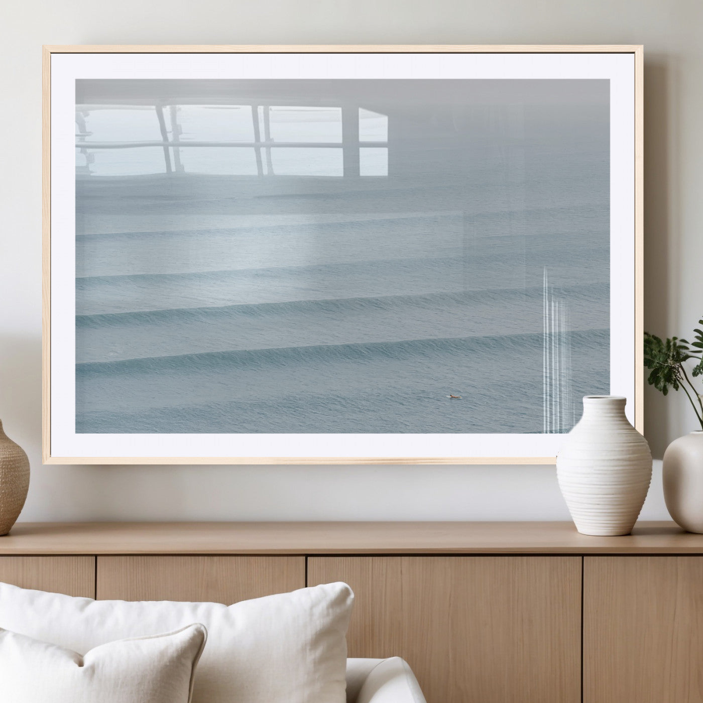 Framed canvas of repeating ocean waves with a distant solo surfer, ideal for minimalist ocean or calm coastal wall decor.