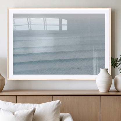 Framed canvas of repeating ocean waves with a distant solo surfer, ideal for minimalist ocean or calm coastal wall decor.