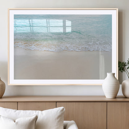 Soft shoreline with gentle aqua waves on smooth sand, ideal for minimalist coastal or pastel ocean-inspired home wall decor.
