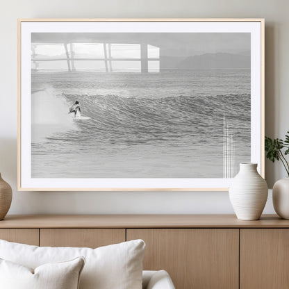 Monochrome photo of a surfer riding a wave with distant mountains, ideal for coastal motion or black and white surf-themed wall decor.