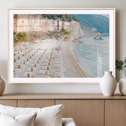 Wall art of a calm Mediterranean beach with rows of sun loungers and umbrellas in soft pastel tones, perfect for light coastal or vacation-themed decor.