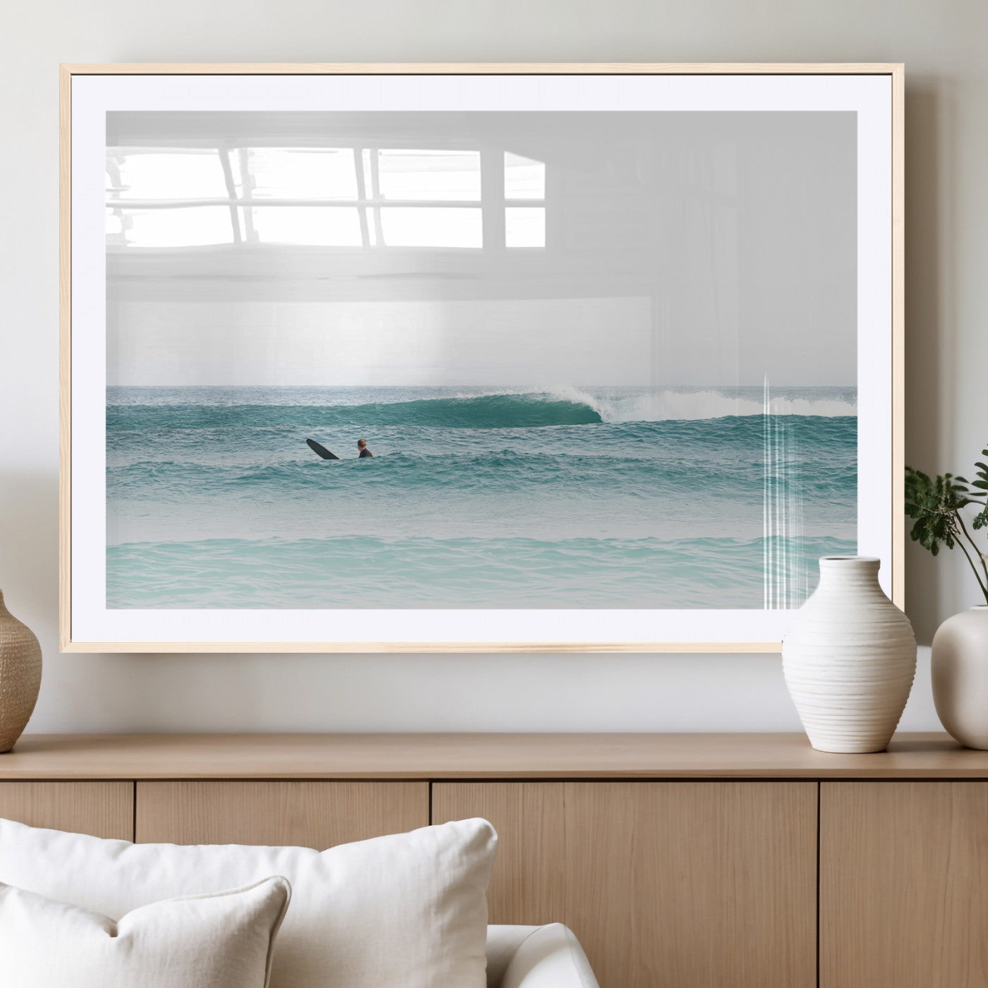 Minimalist photo of a lone surfer on calm aqua waves under bright sky, perfect for Scandinavian coastal or serene ocean-inspired home decor.