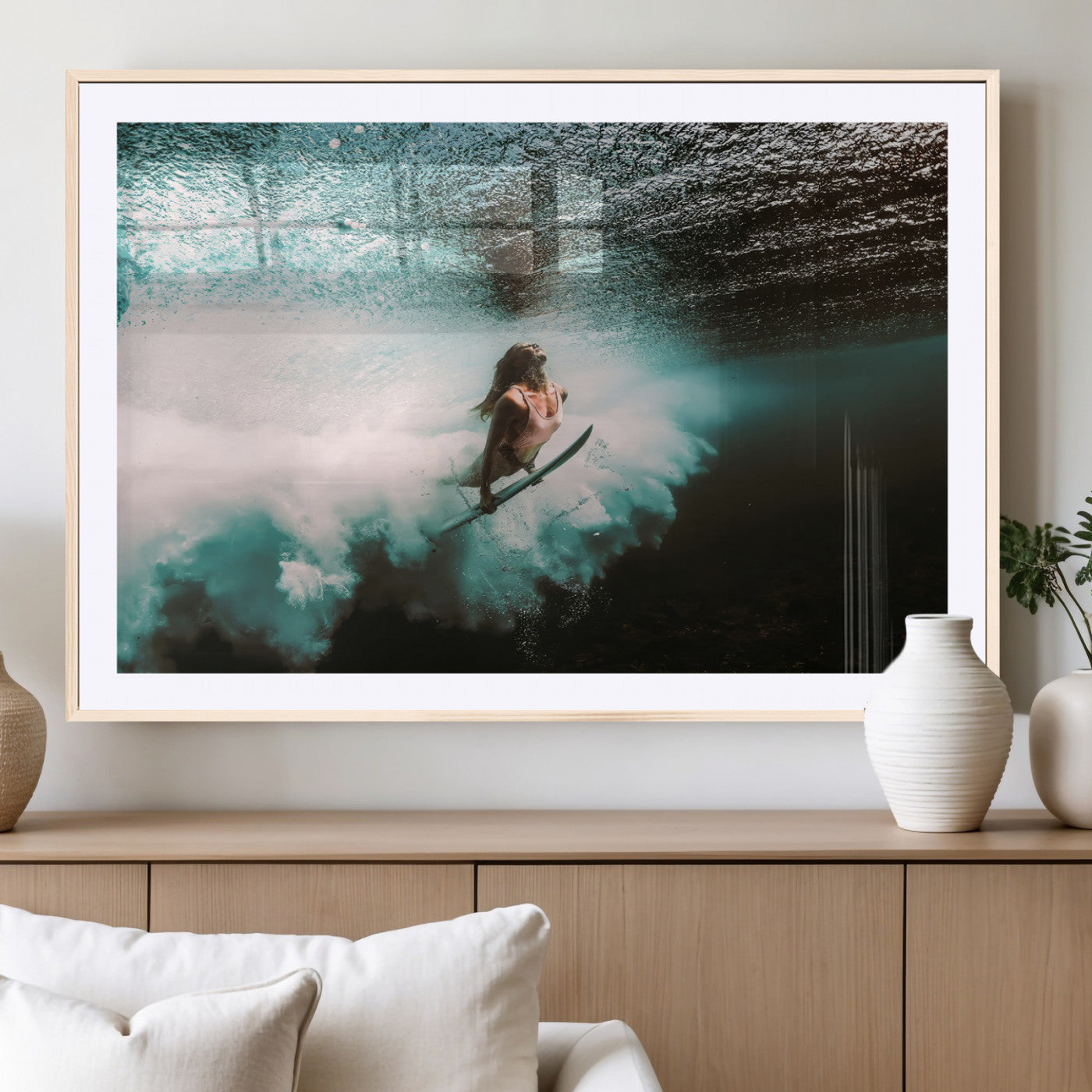 Vibrant underwater photo of a female surfer diving through turquoise waves, perfect for coastal boho or surf-inspired home decor.