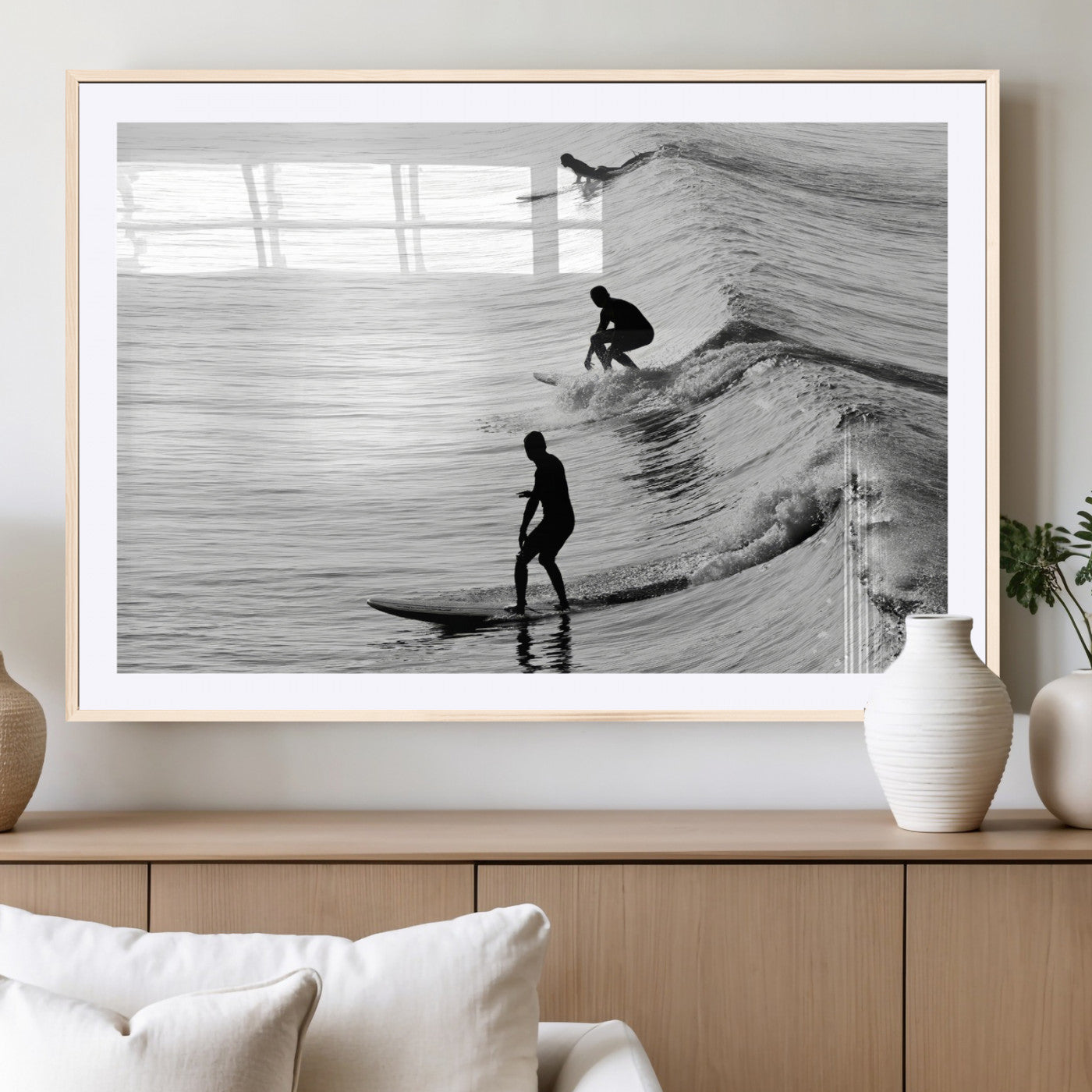 Black and white photo of surfers riding waves in a moody, high-contrast scene, ideal for modern coastal or surf-inspired home decor.