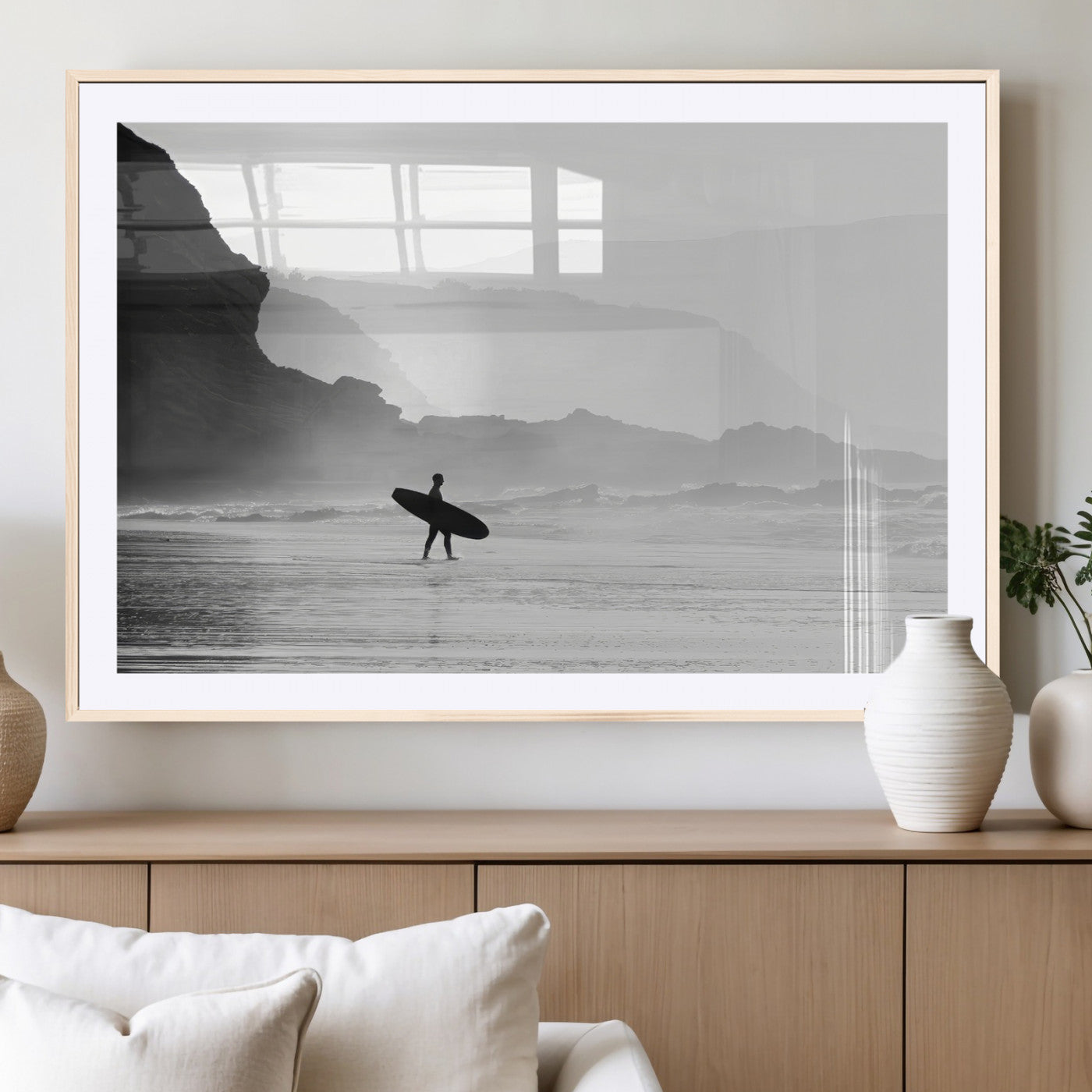 A lone surfer walking along a misty beach with cliffs in the background, carrying their board, capturing a serene and minimal ocean moment.