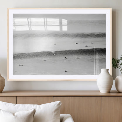 A monochrome photograph of swimmers gliding through gentle ocean waves, evoking a sense of calm and movement.