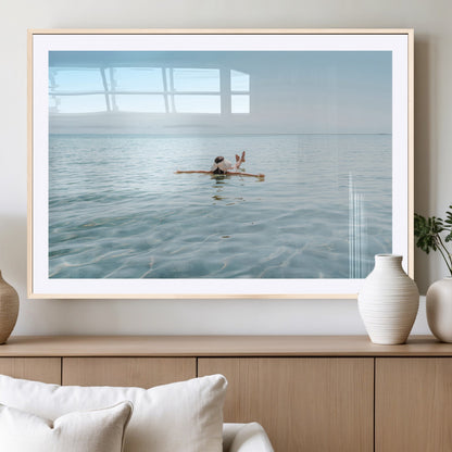 A peaceful minimalist scene of a person floating on crystal-clear water, surrounded by a vast open horizon, capturing relaxation and serenity in a tranquil aquatic setting.