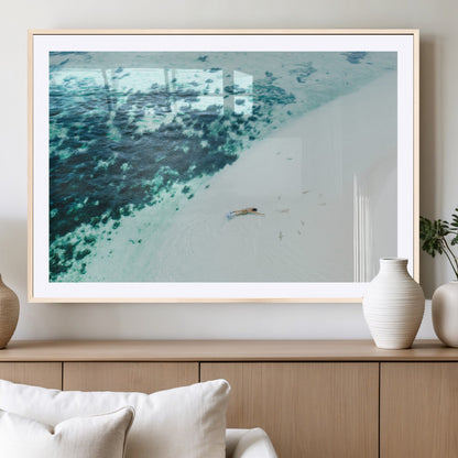 Canvas featuring an aerial view of a swimmer in shallow turquoise waters with coral patterns, ideal for tropical coastal home decor.