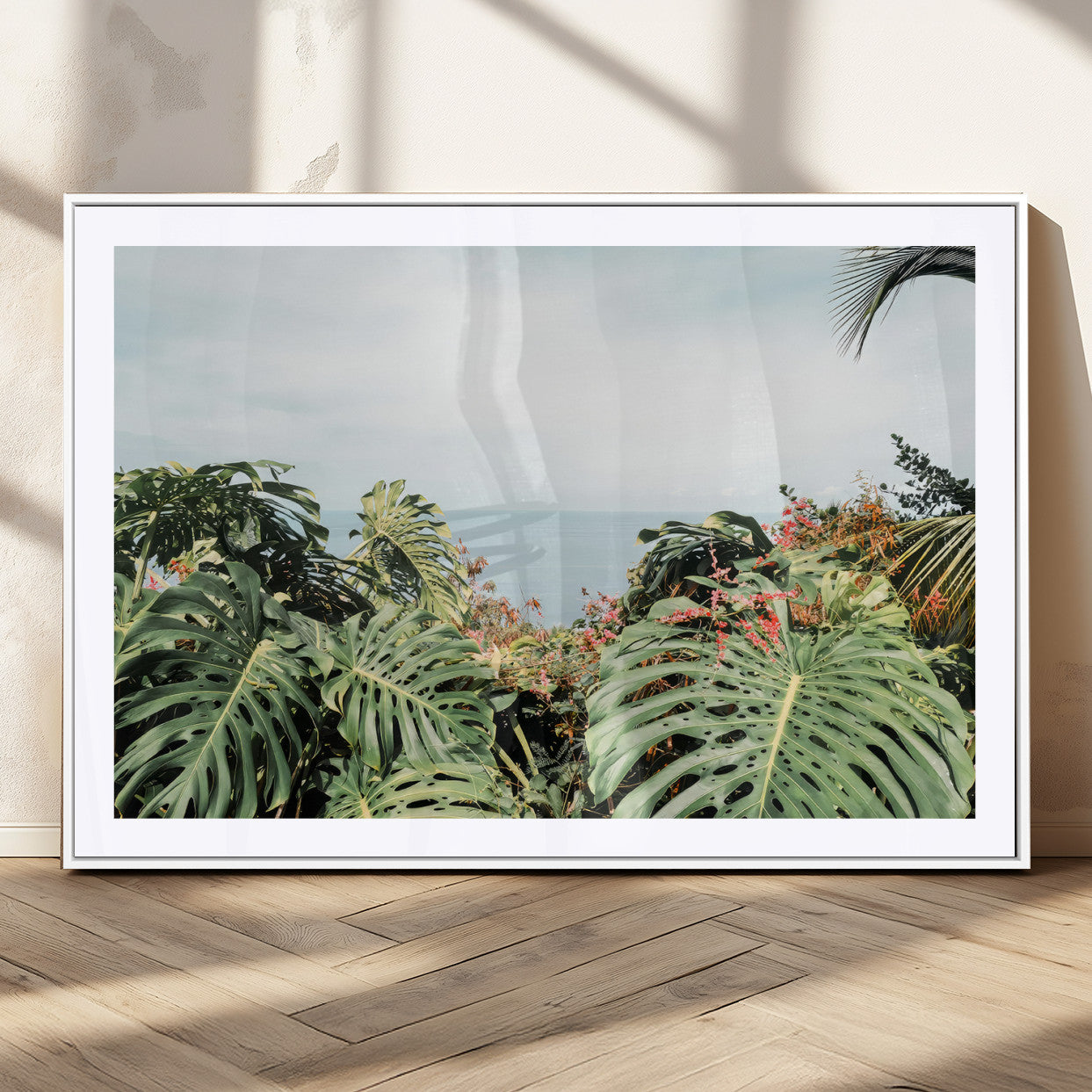 Monstera leaves and tropical flowers framing a calm ocean view, ideal for tropical coastal or exotic jungle-style interior wall decor.