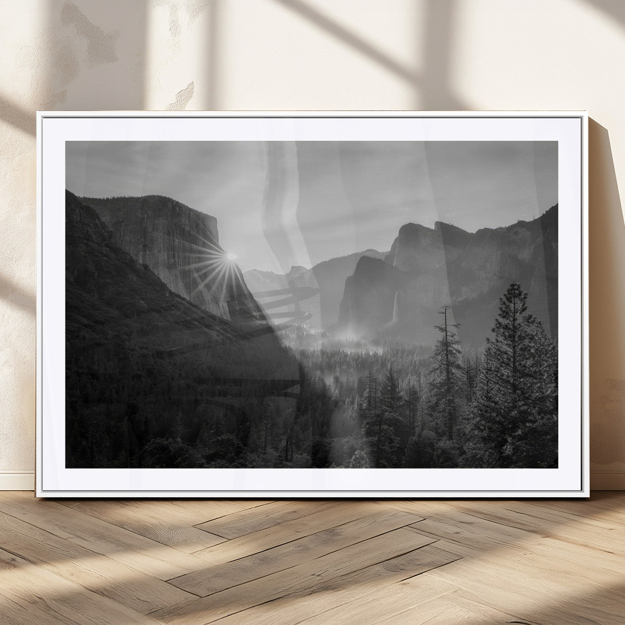 Black and white landscape of Yosemite with sun rays peeking over El Capitan, ideal for moody nature or modern rustic decor.