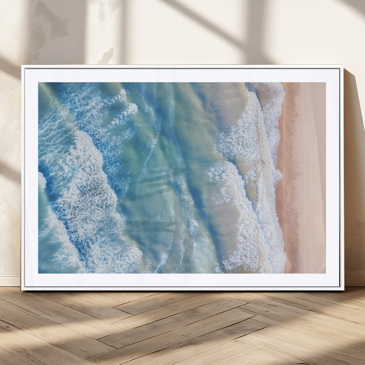 Aerial photo of soft blue waves meeting sandy shore, perfect for modern coastal or beach-themed decor with a light and tranquil aesthetic.