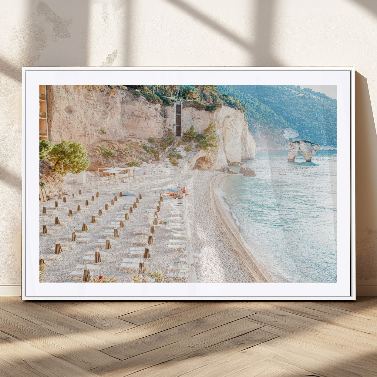 Wall art of a calm Mediterranean beach with rows of sun loungers and umbrellas in soft pastel tones, perfect for light coastal or vacation-themed decor.