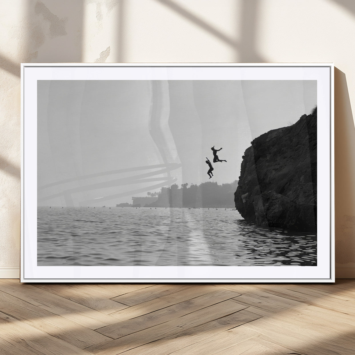 Black and white canvas of two figures cliff jumping into the sea, captured with moody tones, ideal for modern coastal or adventure-themed home decor.   2/2