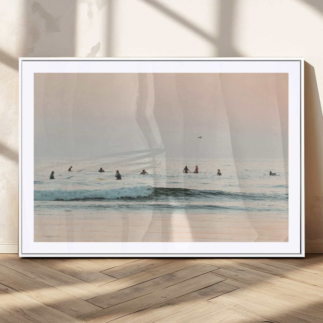 Dreamy photo of surfers waiting on soft pastel waves under a pink sunset sky, ideal for soft coastal minimalist or serene ocean-themed home decor.
