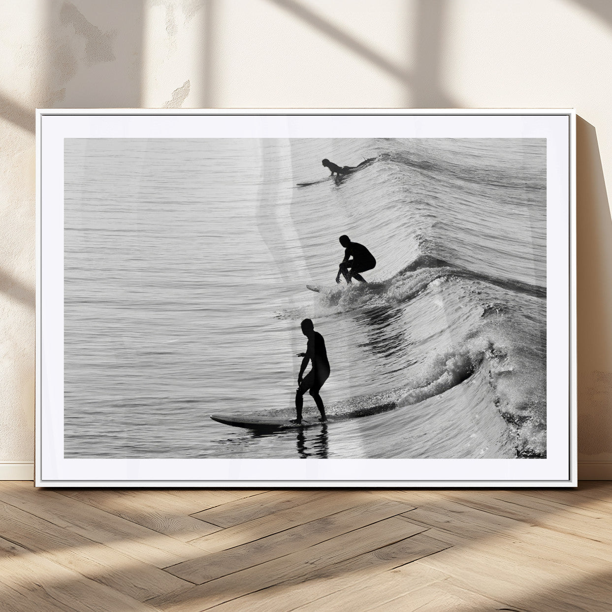 Black and white photo of surfers riding waves in a moody, high-contrast scene, ideal for modern coastal or surf-inspired home decor.