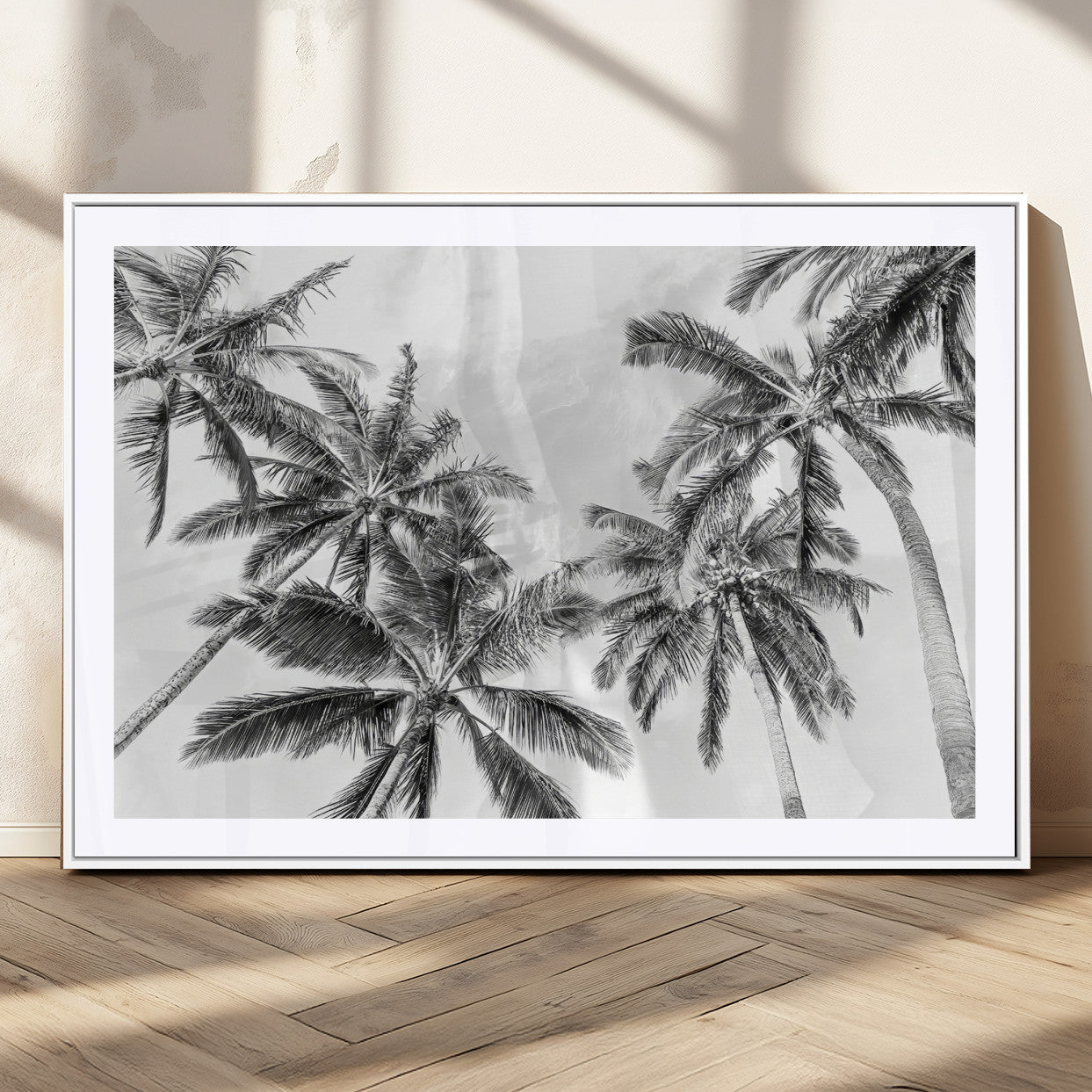 Black and white tropical palm trees viewed from below, swaying gently against a bright sky, creating a serene and elegant coastal atmosphere.