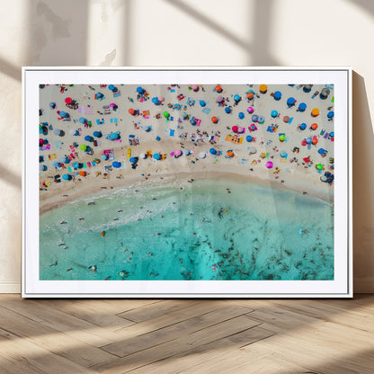 Aerial view of a vibrant beach filled with colorful umbrellas and people enjoying the turquoise ocean, capturing a lively summer vacation scene.