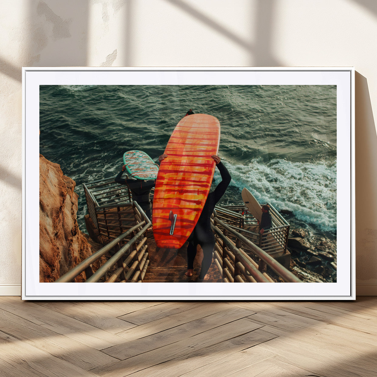 A surfer carrying a bold orange surfboard down a rugged staircase toward the ocean, bathed in golden hour light, capturing the energy of coastal adventure.