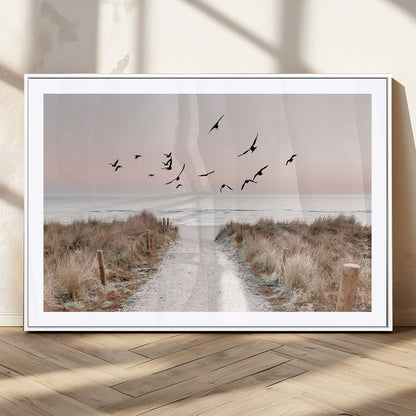 A peaceful coastal pathway leading to the ocean, with birds flying across a soft pastel sky, creating a calm and scenic beach atmosphere.
