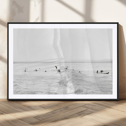 Monochrome photo of surfers riding and waiting on ocean waves, ideal for surf-themed or coastal energy wall decor.