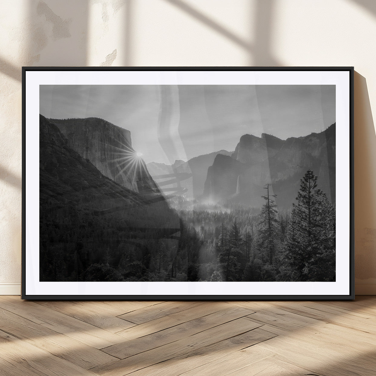 Black and white landscape of Yosemite with sun rays peeking over El Capitan, ideal for moody nature or modern rustic decor.