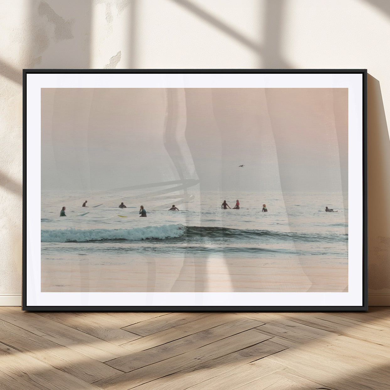 Dreamy photo of surfers waiting on soft pastel waves under a pink sunset sky, ideal for soft coastal minimalist or serene ocean-themed home decor.