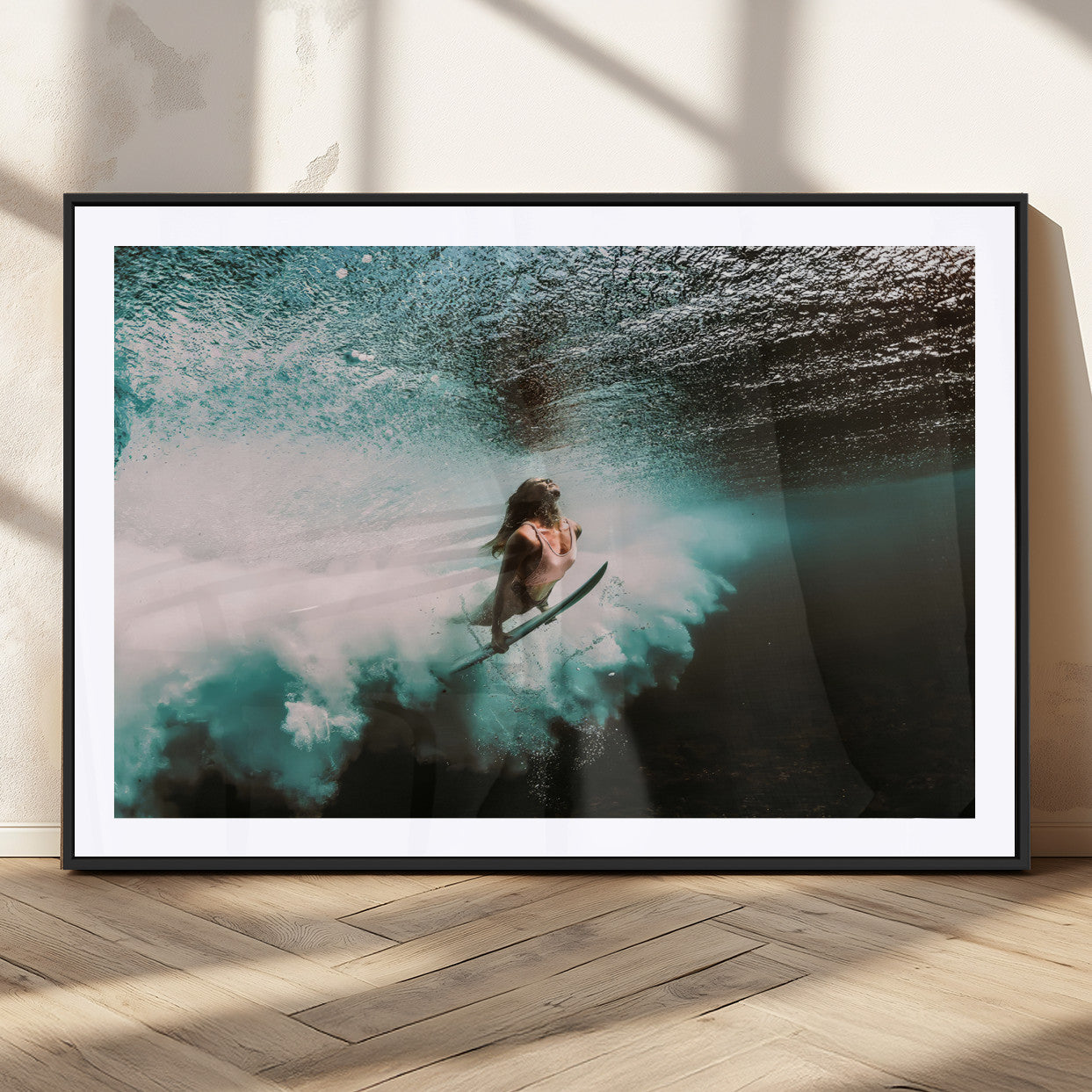 Vibrant underwater photo of a female surfer diving through turquoise waves, perfect for coastal boho or surf-inspired home decor.