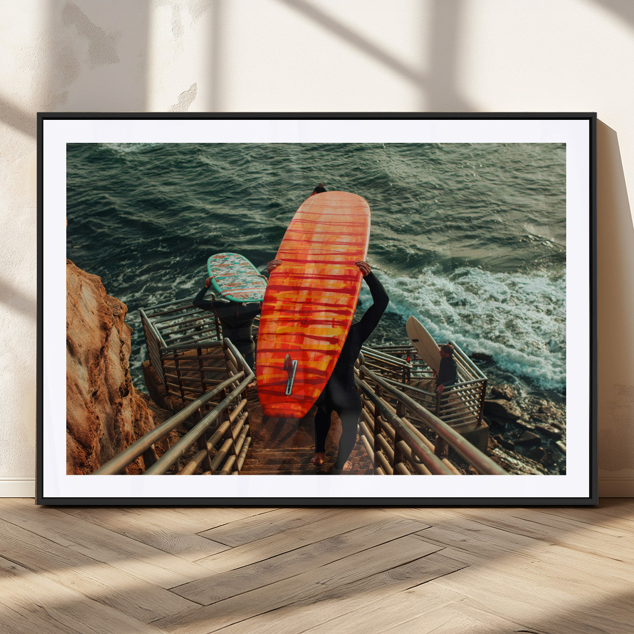 A surfer carrying a bold orange surfboard down a rugged staircase toward the ocean, bathed in golden hour light, capturing the energy of coastal adventure.