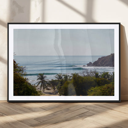 View of calm ocean waves with palm trees and a tropical coastline, ideal for coastal boho or beach-themed wall decor.