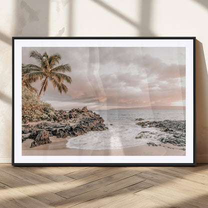 A peaceful beach scene with a palm tree and rocks, soft waves washing onto the shore under a soft pastel sky at sunset.