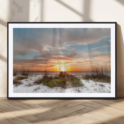 A tranquil beach scene featuring golden sunset hues over the water, with grasses in the foreground and a peaceful, serene atmosphere.