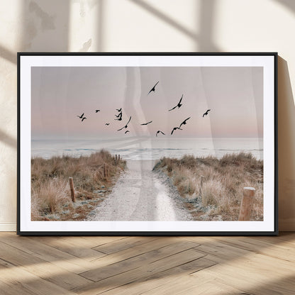 A peaceful coastal pathway leading to the ocean, with birds flying across a soft pastel sky, creating a calm and scenic beach atmosphere.