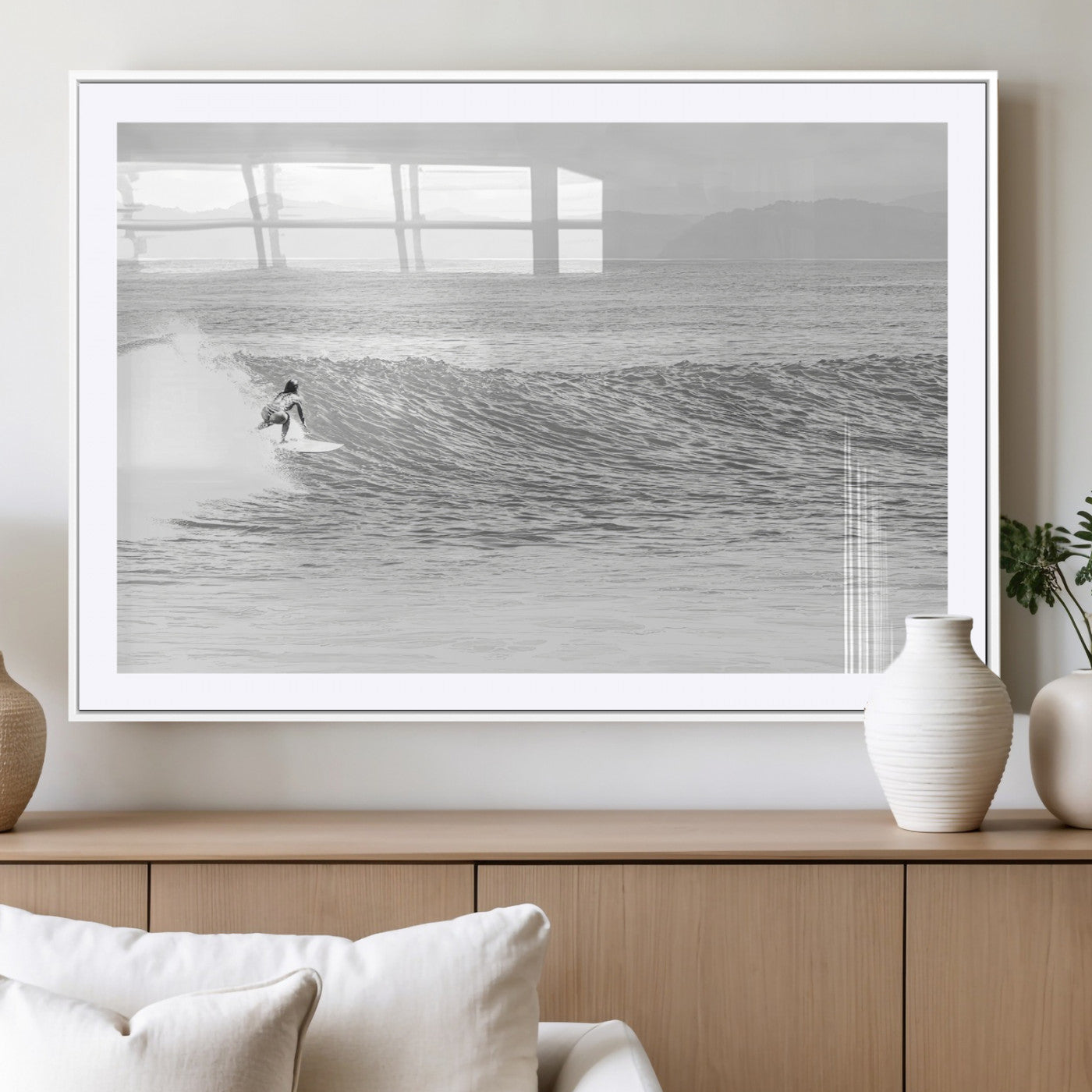 Monochrome photo of a surfer riding a wave with distant mountains, ideal for coastal motion or black and white surf-themed wall decor.