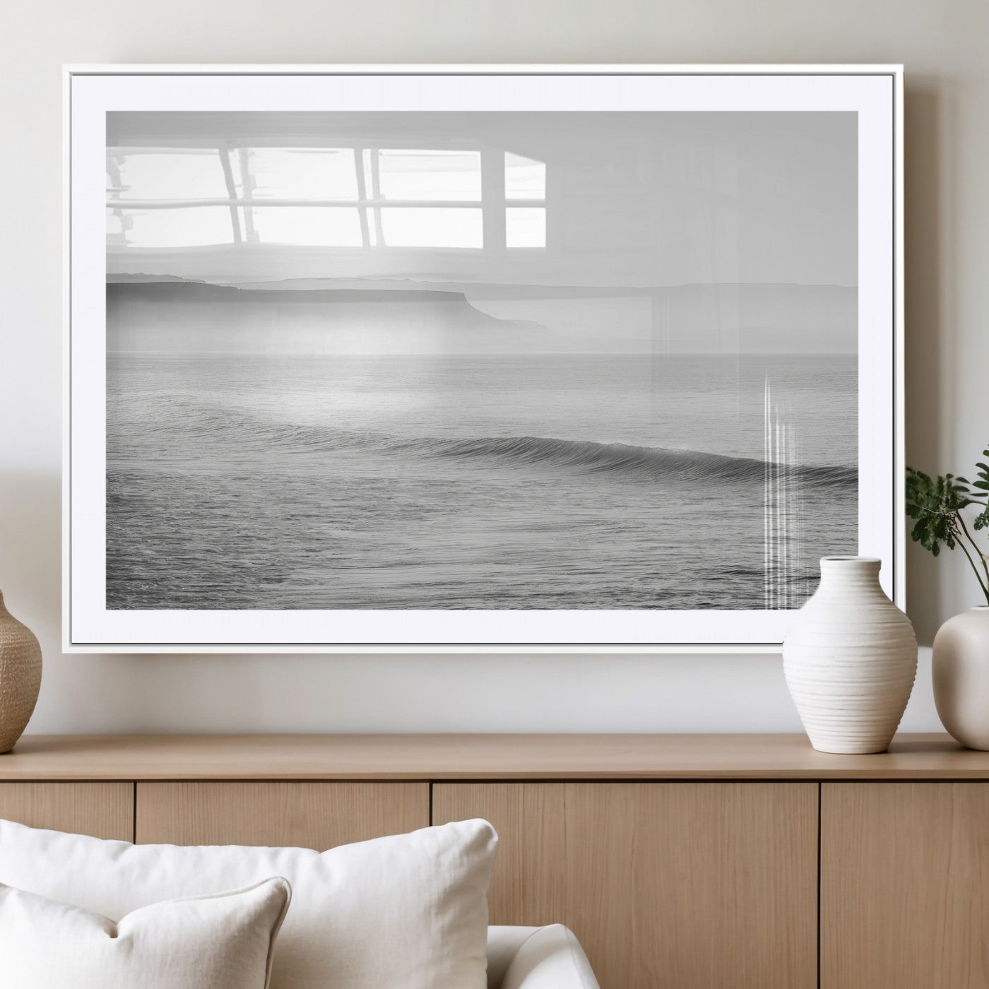 A black and white minimalist seascape featuring soft rolling waves and misty distant cliffs, creating a serene and timeless coastal atmosphere.