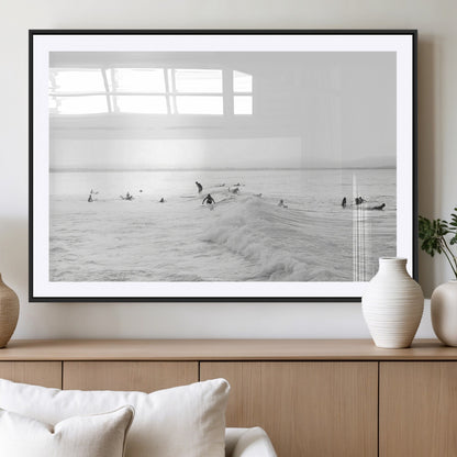 Monochrome photo of surfers riding and waiting on ocean waves, ideal for surf-themed or coastal energy wall decor.