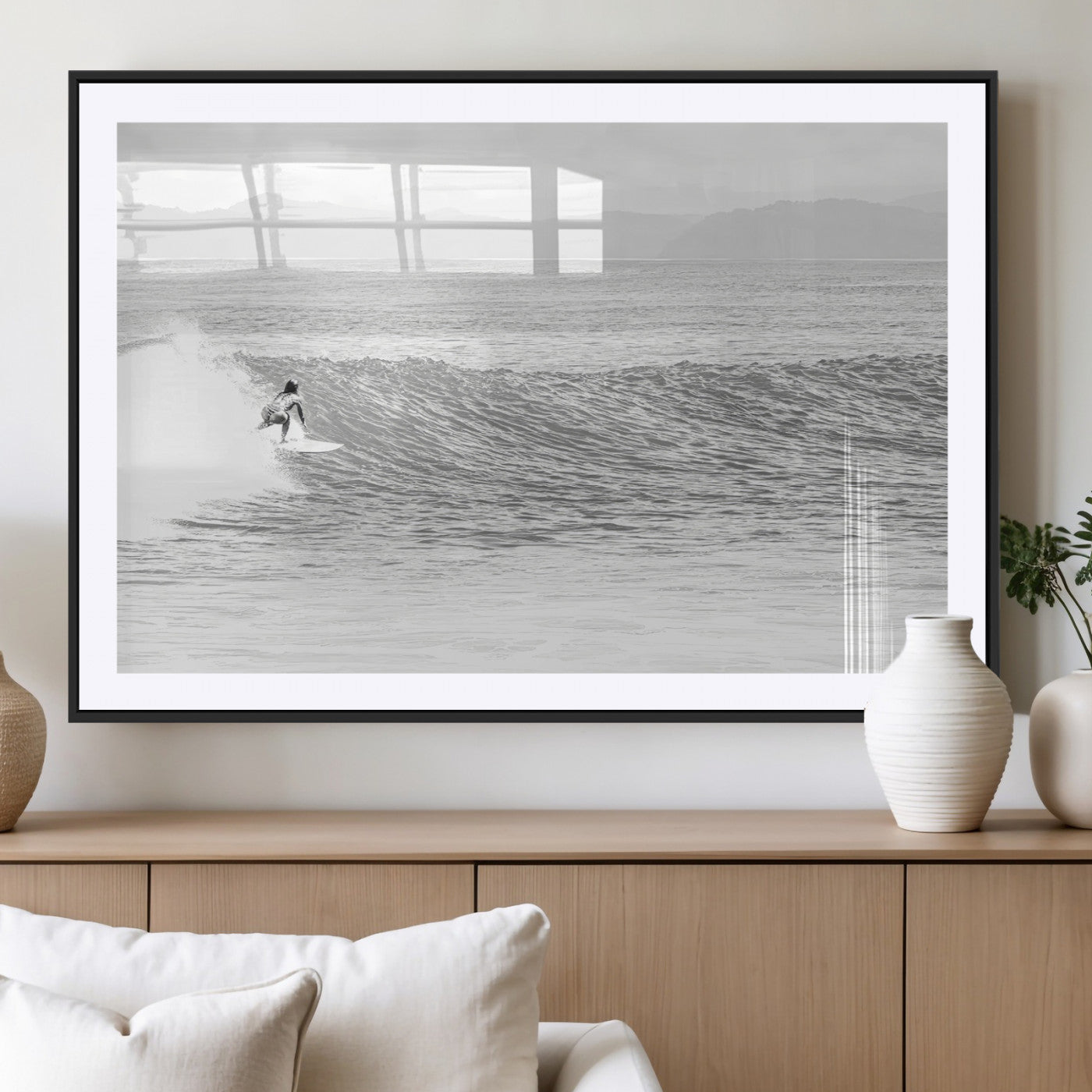 Monochrome photo of a surfer riding a wave with distant mountains, ideal for coastal motion or black and white surf-themed wall decor.