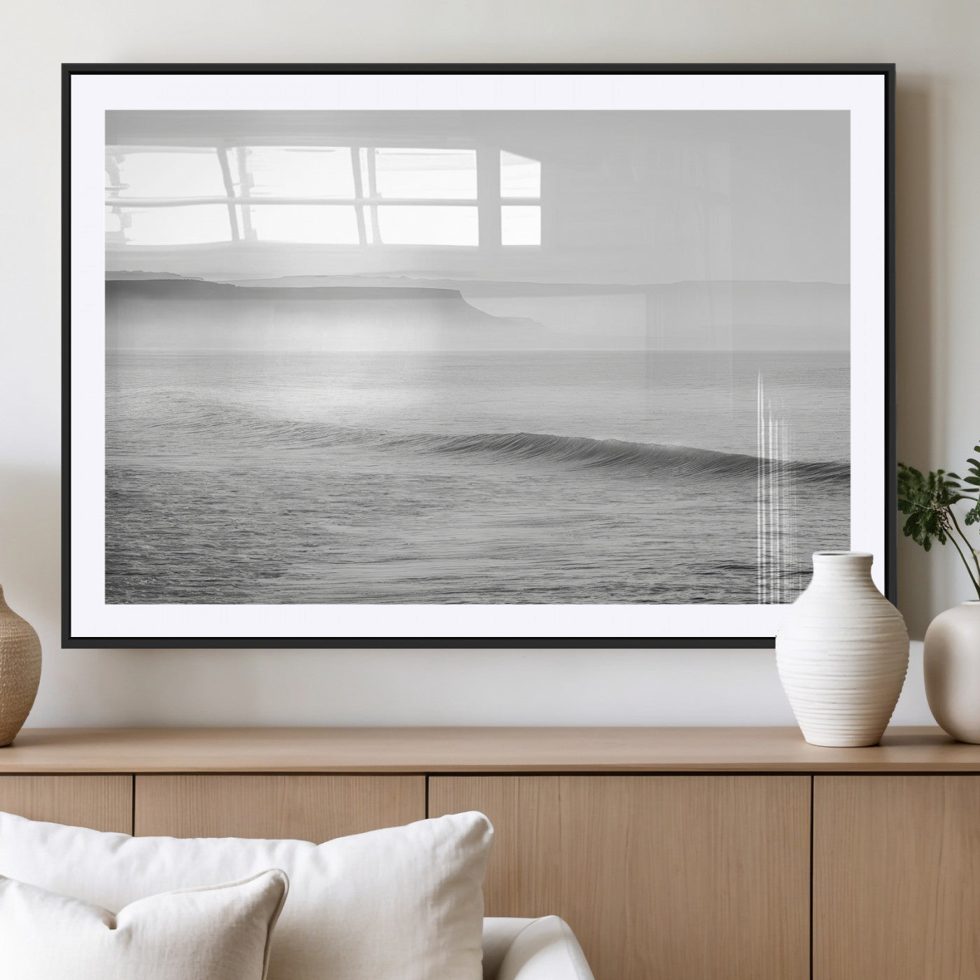 A black and white minimalist seascape featuring soft rolling waves and misty distant cliffs, creating a serene and timeless coastal atmosphere.