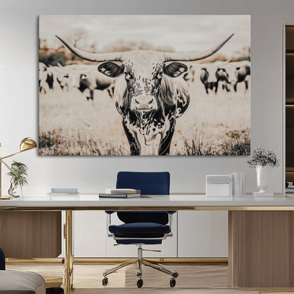 Canvas of a speckled Texas longhorn standing boldly in a field with a herd behind, perfect for rustic western or farmhouse wall decor.