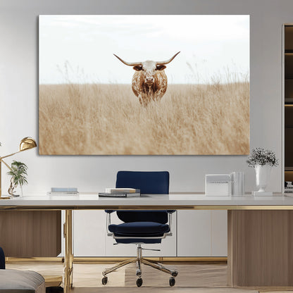 Texas Longhorn bull standing alone in dry grass with neutral tones, ideal for rustic western or cowboy-themed wall decor.