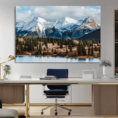 Framed canvas of snowy mountain peaks with pine forest and alpine lake, perfect for winter cabin or wilderness-inspired home decor.