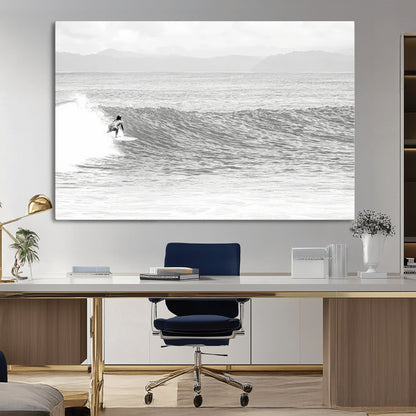 Monochrome photo of a surfer riding a wave with distant mountains, ideal for coastal motion or black and white surf-themed wall decor.