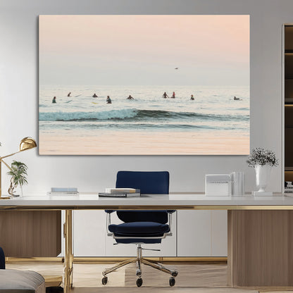 Dreamy photo of surfers waiting on soft pastel waves under a pink sunset sky, ideal for soft coastal minimalist or serene ocean-themed home decor.