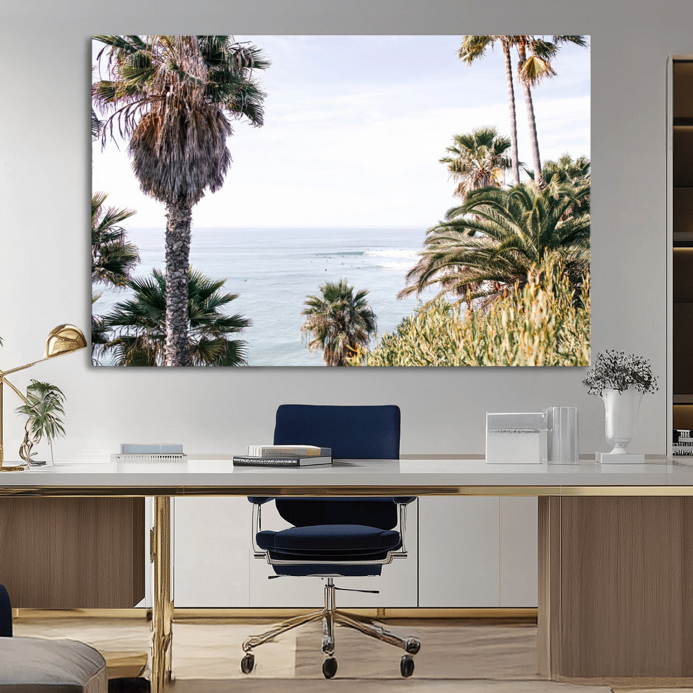 Scenic coastal view with tall palm trees overlooking a calm ocean, soft blue waves, and surfers in the distance, creating a peaceful tropical vibe.