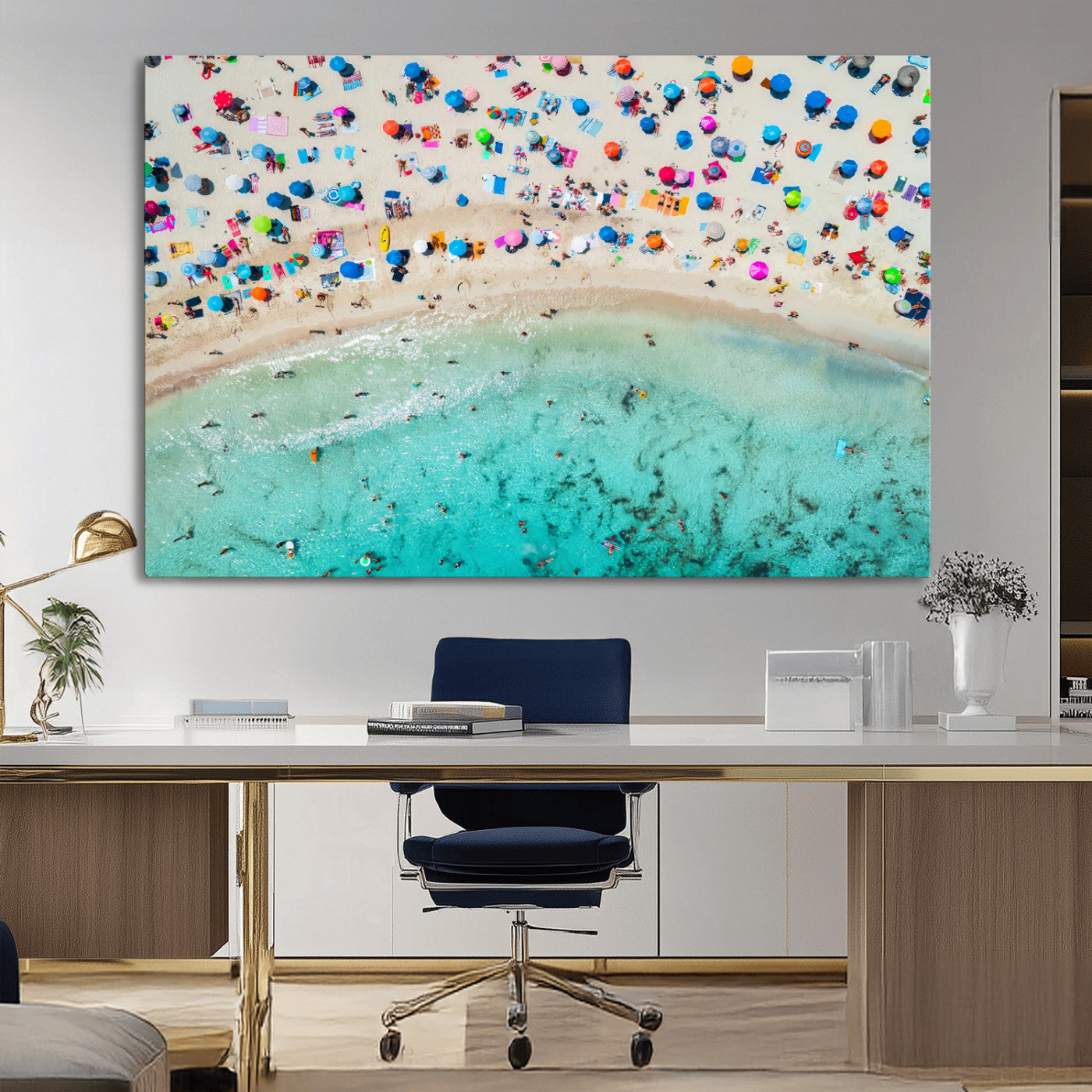 Aerial view of a vibrant beach filled with colorful umbrellas and people enjoying the turquoise ocean, capturing a lively summer vacation scene.