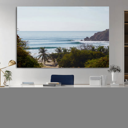 View of calm ocean waves with palm trees and a tropical coastline, ideal for coastal boho or beach-themed wall decor.