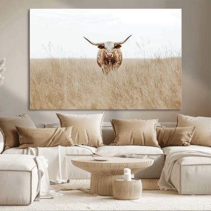 Texas Longhorn bull standing alone in dry grass with neutral tones, ideal for rustic western or cowboy-themed wall decor.