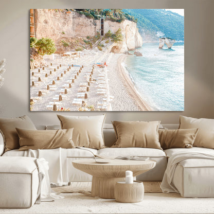 Wall art of a calm Mediterranean beach with rows of sun loungers and umbrellas in soft pastel tones, perfect for light coastal or vacation-themed decor.