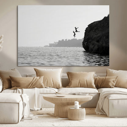 Black and white canvas of two figures cliff jumping into the sea, captured with moody tones, ideal for modern coastal or adventure-themed home decor.   2/2