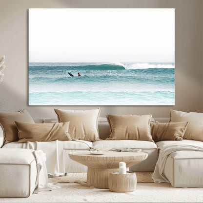 Minimalist photo of a lone surfer on calm aqua waves under bright sky, perfect for Scandinavian coastal or serene ocean-inspired home decor.