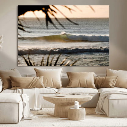 Photo of a surfer riding a golden hour wave at sunset, with tropical tones and dreamy light, perfect for tropical boho or coastal home decor.
